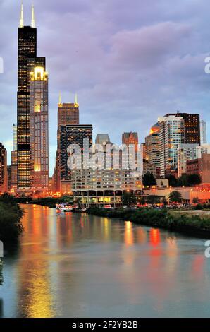 Chicago, Illinois, USA. Als die Nacht beginnt, die Dämmerung entlang des South Branch of the Chicago River zu ersetzen, leuchten Lichter in Gebäuden rund um den Fluss. Stockfoto