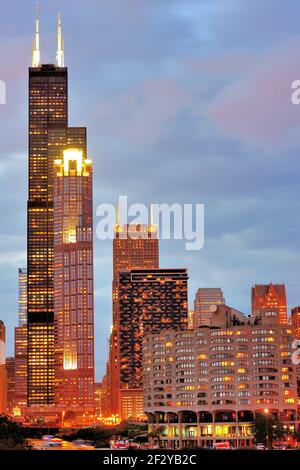 Chicago, Illinois, USA. Als die Nacht beginnt, die Dämmerung entlang des South Branch of the Chicago River zu ersetzen, leuchten Lichter in Gebäuden rund um den Fluss. Stockfoto