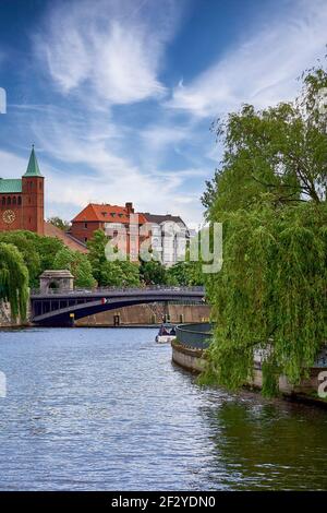 Kleines Boot schwimmt auf Flusswasser unter Brücke in der Nähe der historischen St. Nikolaus Kirche entlang der Spree Kanal Stockfoto