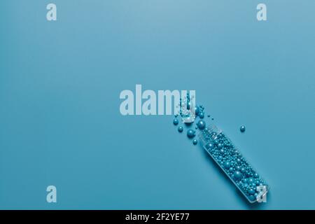 Glas und blaue Kugeln mit verschiedenen Durchmessern auf einem Blauer Hintergrund Stockfoto
