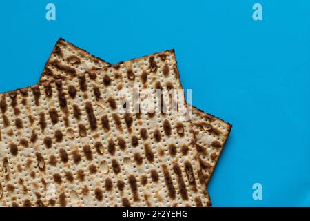 Eine Nahaufnahme von zwei Matzahs - Brot für das jüdische Passah, auf hellblauem Hintergrund Stockfoto