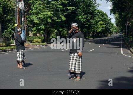 Denpasar, Indonesien. März 2021, 14th. Balinese traditionelle Sicherheit von Pecalang stehen auf Wache an den Hauptverkehrsstraßen von Denpasar. Bali Island feiert Nyepi, den Tag der Stille. Nyepi ist der hinduistische balinesische Feiertag der Selbstreflexion, in dem alle Aktivitäten gestoppt werden und die Menschen nicht nach draußen kommen dürfen, wenn alle Lichter niedrig gehalten werden, keine Arbeit und keine Freuden. Kredit: SOPA Images Limited/Alamy Live Nachrichten Stockfoto