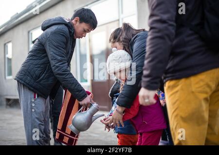 Abendessen mit einer lokalen uigurischen Familie in der Stadt Karakol im kirgisischen Issyk Kol Gebiet. Stockfoto