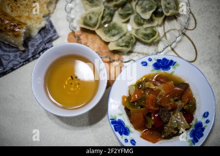 Abendessen mit einer lokalen uigurischen Familie in der Stadt Karakol im kirgisischen Issyk Kol Gebiet. Stockfoto