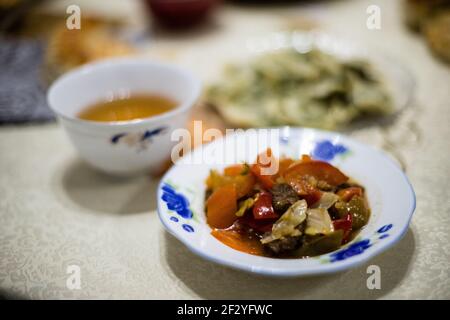 Abendessen mit einer lokalen uigurischen Familie in der Stadt Karakol im kirgisischen Issyk Kol Gebiet. Stockfoto