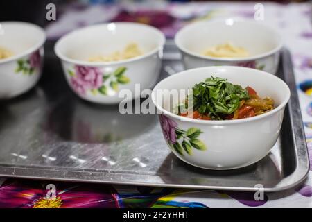 Abendessen mit einer lokalen uigurischen Familie in der Stadt Karakol im kirgisischen Issyk Kol Gebiet. Stockfoto