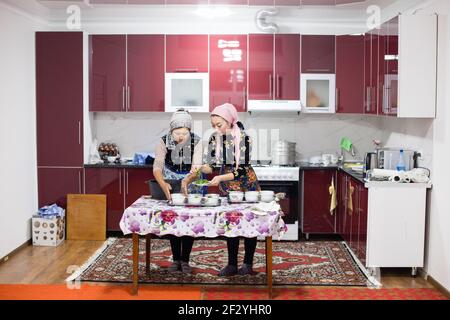 Abendessen mit einer lokalen uigurischen Familie in der Stadt Karakol im kirgisischen Issyk Kol Gebiet. Stockfoto