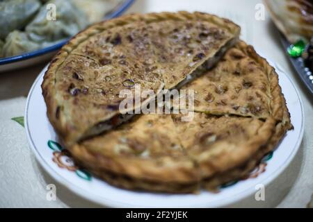 Abendessen mit einer lokalen uigurischen Familie in der Stadt Karakol im kirgisischen Issyk Kol Gebiet. Stockfoto