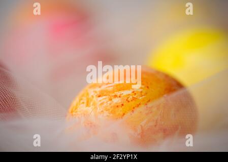 Handbemalte pastellfarbene Ostereier auf weißem Seidenstoff Nahaufnahme Stockfoto