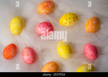 Handbemalte pastellfarbene Ostereier auf weißem Seidenstoff Nahaufnahme Stockfoto