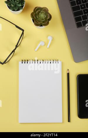 Bürotisch Schreibtisch, Arbeitsplatz mit Notebook, Handy, Computer, grüne Pflanze und Brillen. Geschäftlicher Hintergrund.flache Lage, Draufsicht.Kopierbereich Stockfoto