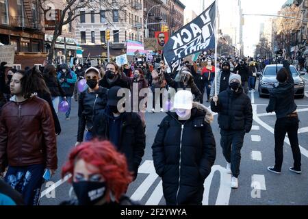 Eine Protesterin marschierte während der Demonstration mit der Flagge "Schwarze Menschenleben".zum einjährigen Jahrestag der Schüsse von Breonna Taylor in ihrer Residenz versammelten sich Demonstranten am Times Square. Taylor, ein Techniker in der Notaufnahme, wurde am 13. März 2020 während einer verpfuschten Polizeirazzia getötet, bei der die Polizei behauptet, dass Taylors' Freund den ersten Schuss abgefeuert habe, nachdem die Beamten sich selbst angekündigt hatten und einen Offizier verwundeten. Sechs Monate nach dem Drogenrazzia wurde der Familie Taylor 12 Millionen Dollar als ungerechtfertigter Todesfall mit der Stadt Louisville Kentucky zugesprochen, die diesen anschließenden Chang festlegt Stockfoto