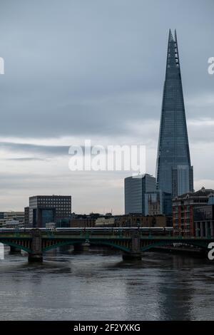 London UK Februar 2021 Blick auf die Themse an einem kalten Wintertag erhebt sich der Shard Wolkenkratzer über den Gebäuden. Weißer Zug, der die überquert Stockfoto