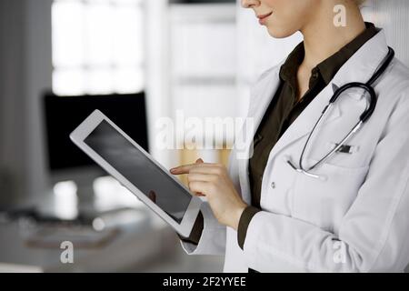 Unbekannter weiblicher Arzt mit Tablet-Computer in der Klinik. Perfekter medizinischer Service im Krankenhaus. Medizinkonzept Stockfoto