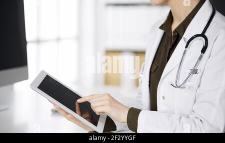 Unbekannter weiblicher Arzt mit Tablet-Computer in der Klinik. Perfekter medizinischer Service im Krankenhaus. Medizinkonzept Stockfoto