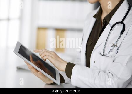 Unbekannter weiblicher Arzt mit Tablet-Computer in der Klinik. Perfekter medizinischer Service im Krankenhaus. Medizinkonzept Stockfoto