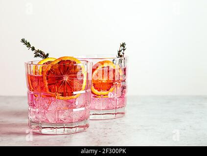 Pink Gin Cocktail mit roter Blutorange und Eis. Ein alkoholisches, erfrischendes Getränk. Stockfoto