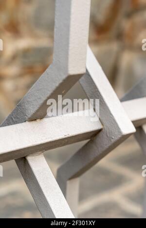 Minimalistische Geometrie im Kontrast zu verdrehtem weißem Eisen, Details der urbanen Landschaft, die uns anonym umgeben. Stockfoto