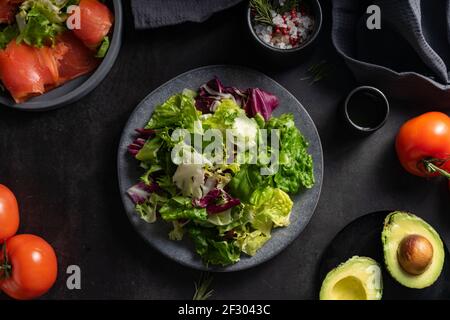 Selektiver Fokus. Grüner Salat aus frischen Kräutern, natürliche Nahrung. Auf dunklem Hintergrund in einer niedrigen Taste. Basis für einen leichten Snack Stockfoto