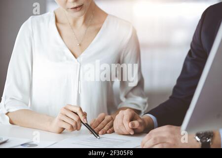 Unbekannte Geschäftsmann und Frau diskutieren Vertrag in sonnigen Büro, close-up.Business Menschen oder Anwälte arbeiten zusammen bei der Sitzung Stockfoto