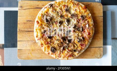 margarita Pizza, frisch gebacken auf einem Schneidebrett mit geschmolzenem Käse Stockfoto