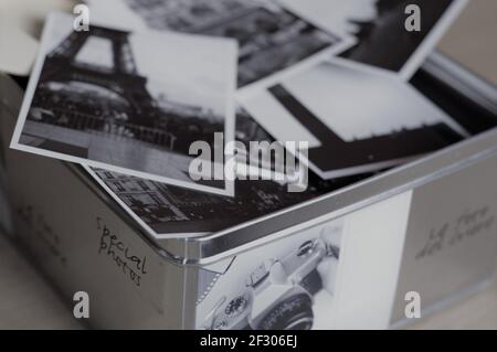 Nahaufnahme einer Metallkiste voller Fotos, die in Paris mit dem Eiffelturm im Vordergrund in einem Schwarz-Weiß-Bild aufgenommen wurden Stockfoto