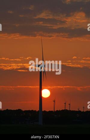 Schöner orangefarbener Sonnenuntergang hinter Windturbinen Stockfoto