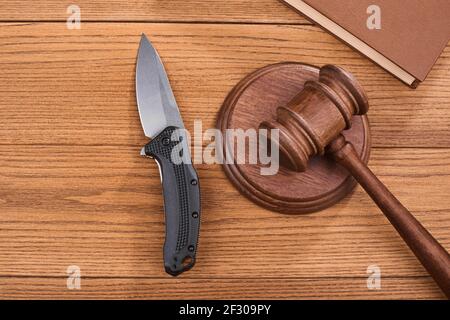 Draufsicht auf einem Taschenmesser, einem Richtergavel und einem Buch auf Holzhintergrund Stockfoto