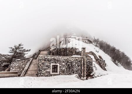 Steinhaus auf dem Berg im Nebel versteckt Stockfoto