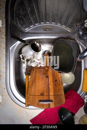 Viel schmutziges Geschirr und ein Durcheinander in der Spülbecken in der Küche Stockfoto