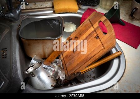 Viel schmutziges Geschirr und ein Durcheinander in der Spülbecken in der Küche Stockfoto