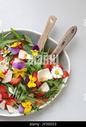 Erdbeer-Rucola-Salat mit Erdbeeren, Rocola, Parmesan und gehörntem Stiefmütterchen Stockfoto