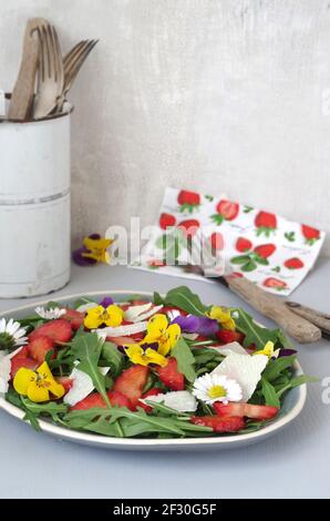 Erdbeer-Rucola-Salat mit Erdbeeren, Rocola, Parmesan und gehörntem Stiefmütterchen Stockfoto