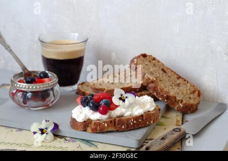 Getreidebrot mit Frischkäse und Sommerbeersalat Stockfoto