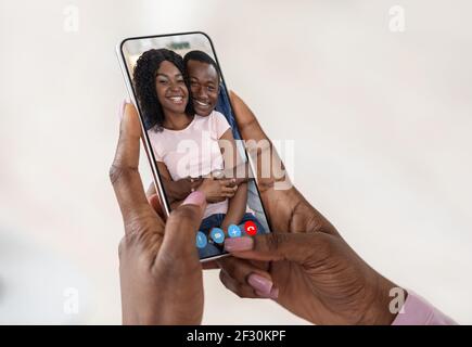 Ferne Freundschaft. Schwarze Frau Macht Video Anruf Auf Smartphone Mit Afrikanischen Paar Stockfoto