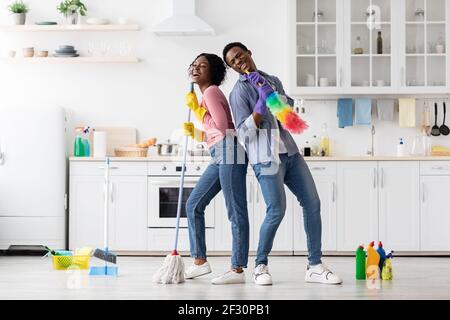Fröhliche afroamerikanische Familie, die Spaß beim Reinigen der Küche hat Stockfoto