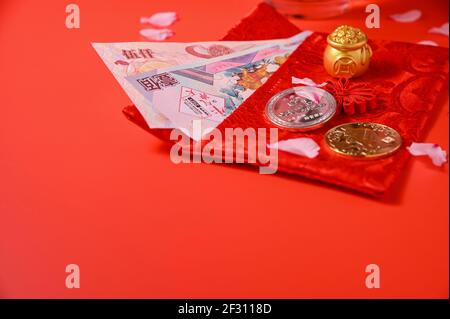 Chinesisches Neujahr 2021 ist Jahr des Ochsen, chinesische Zeichen. Chinesische Neujahrsschmuck. Goldbarren und goldener Abakus. Blühende Mandelblüten und Münzen auf rotem Hintergrund. Speicherplatz kopieren Stockfoto