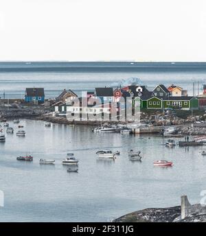 Das farbenfrohe Haus von Ilulissat, Grönland. Kangia-eisfjord bedeckt mit Nebel im Hintergrund mit Eisbergen. Konzept der globalen Erwärmung. Stockfoto