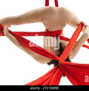 Luftakrobatin macht akrobatische Tricks auf aerial Silk Stockfoto