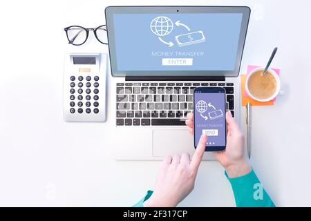 Draufsicht Aufnahme der Frau Hand mit Smartphone und Laptop während Online-Banking. Stockfoto