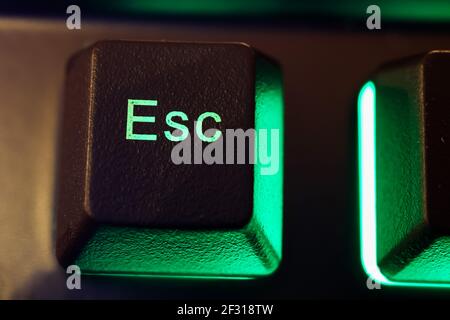 Makro Nahaufnahme der isolierten grün beleuchteten esc-Taste am Computer Tastatur (Fokus auf Buchstabe S) Stockfoto