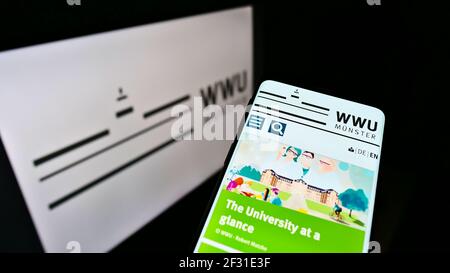 Mobiltelefon mit Webseite der Westfälischen Wilhelms-Universität Münster (WWU) auf dem Bildschirm vor dem Logo. Konzentrieren Sie sich auf die obere Mitte des Telefondisplays. Stockfoto