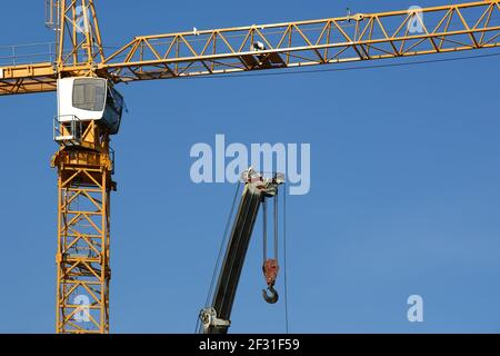 Moderne Baukräne auf blauem Himmel Hintergrund Stockfoto