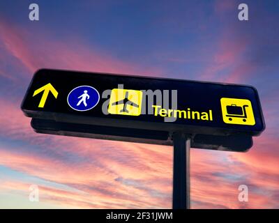 Flughafenschild Schilder Konzept Reise Sonnenaufgang auf Airline Passagier Terminal Richtung Informationstafel. Konzeptkonzepte neue Morgenröte Beginn der Fluggastreise Beschilderung für abfliegende Urlaubsfluggäste, die zu Terminals, Fluggesellschaften, Gepäckausgabe, Gehweg Check-in Stockfoto