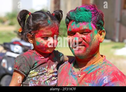 Beawar, Rajasthan, Indien, 24. März 2016: Porträt des indischen Mannes mit Tochter in Farbe Pulver beschmiert feiern Holi, die hinduistischen Frühlingsfest von Co Stockfoto