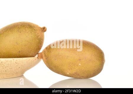 Zwei reife leckere, süße, Bio-Golden Kiwi Früchte, auf einer hellen Keramik-Untertasse, Nahaufnahme, auf weißem Hintergrund Stockfoto