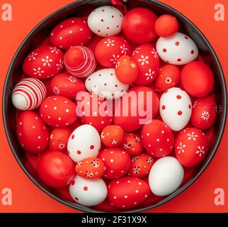 Easter Eggs Kollektion rot und weiß Farbe runde Form Stapel auf rotem Hintergrund, Draufsicht. Frohe Ostern Grußkarte. Christliche Religion Feiertag Promi Stockfoto