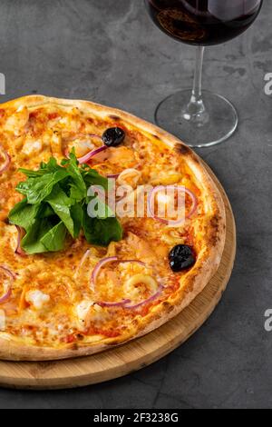 Köstliche Meeresfrüchte-Pizza auf dunkelgrauem Steintisch Stockfoto