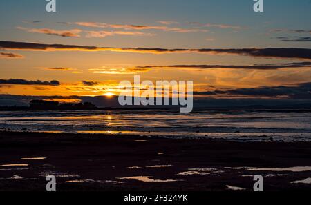 East Lothian, Schottland, Großbritannien, 14th. März 2021. UK Wetter: Sonnenuntergang im Aberlady Naturreservat. Die Sonne geht über dem Watt und sumpfigen Feuchtgebiet in Aberlady Bay unter Stockfoto