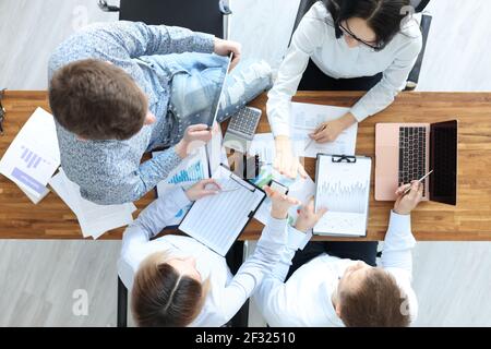 Geschäftsleute an ihrem Schreibtisch geben sich fünf Stockfoto